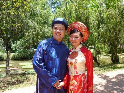 赤いアオザイを着たベトナム人女性と男性